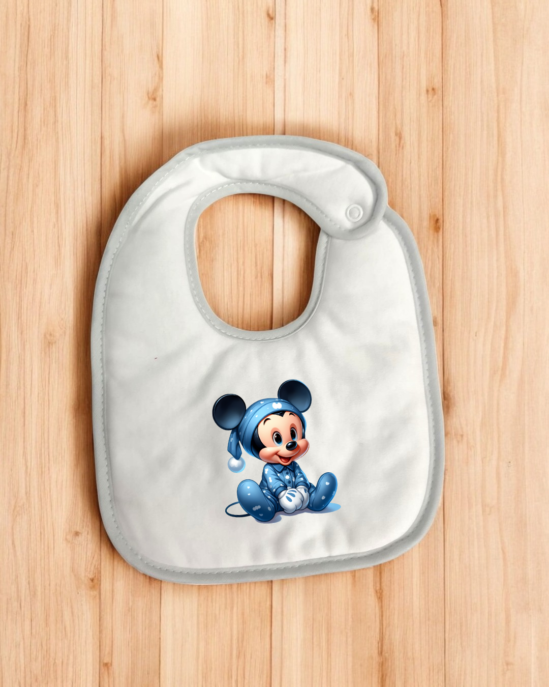 Babete branco com imagem de Mickey bebé em pijama azul