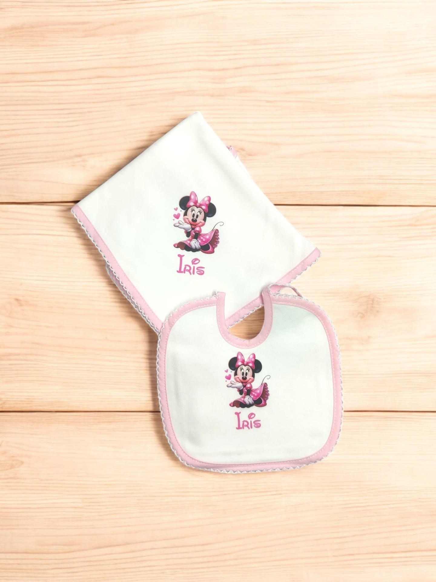 Babete e toalha brancos com borda rosa e imagem da Minnie com nome Iris