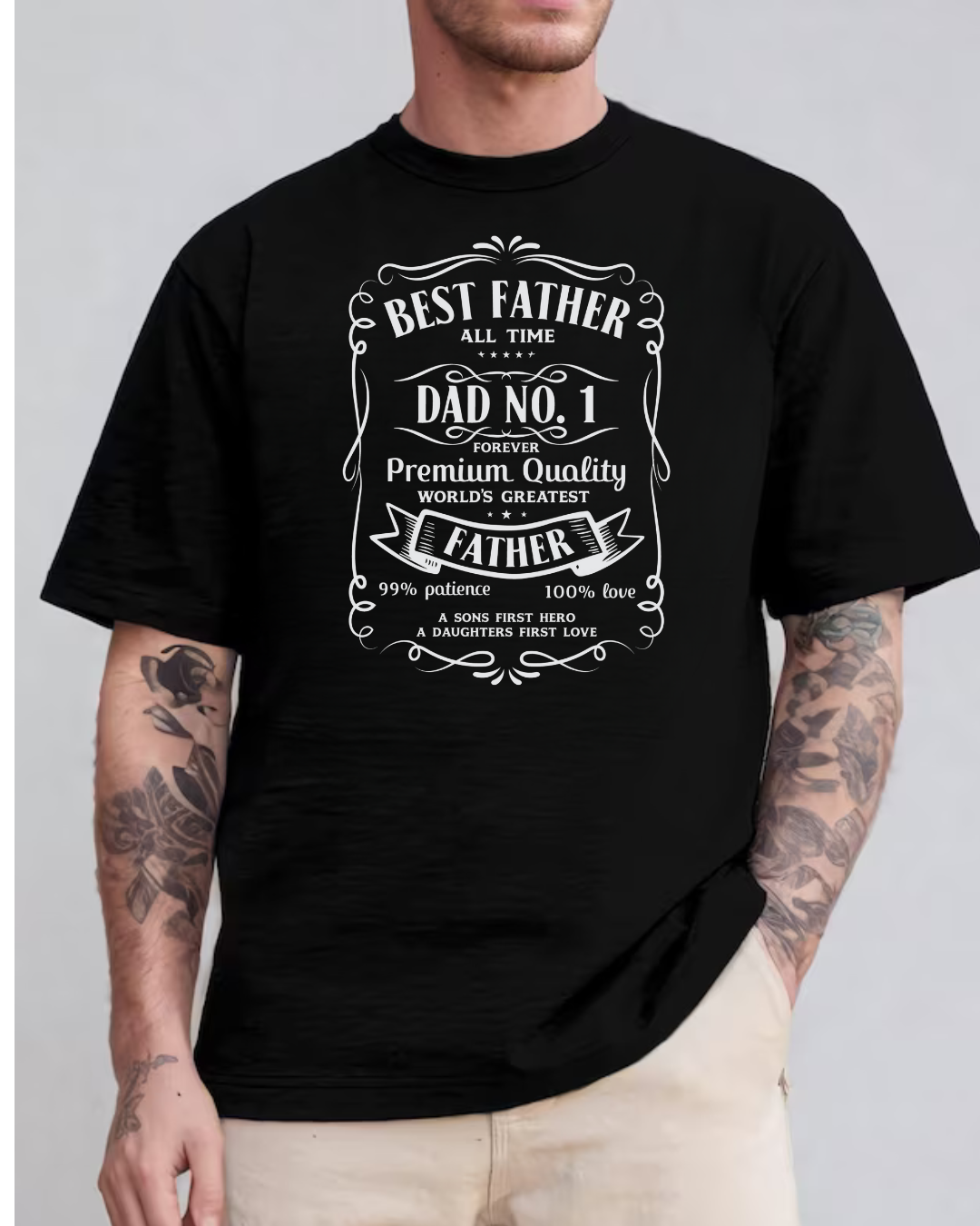 Camiseta preta com texto branco sobre paternidade e tatuagens nos braços do modelo