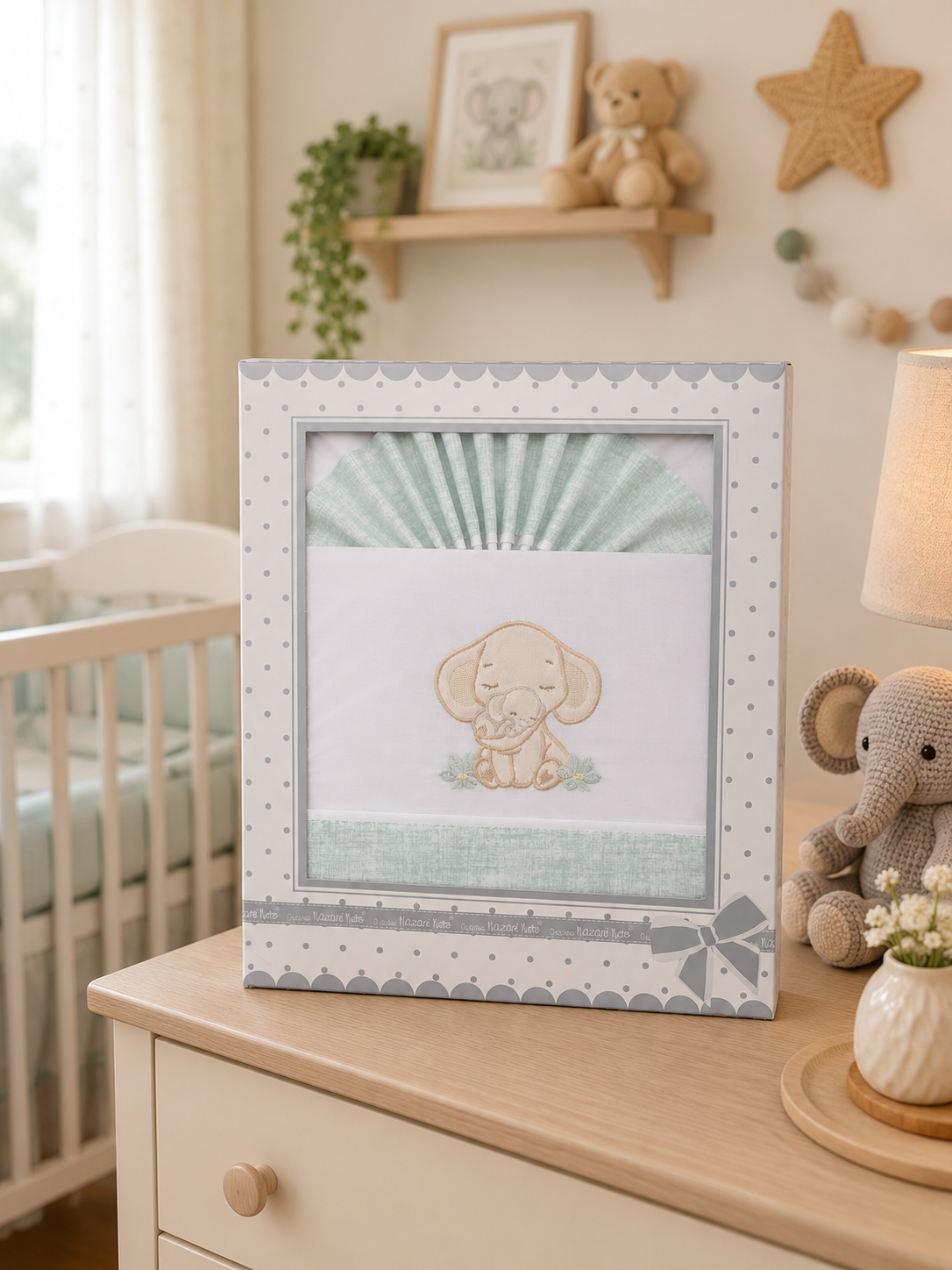 Caixa com jogo de cama bordado com elefante, móvel de madeira e decoração infantil