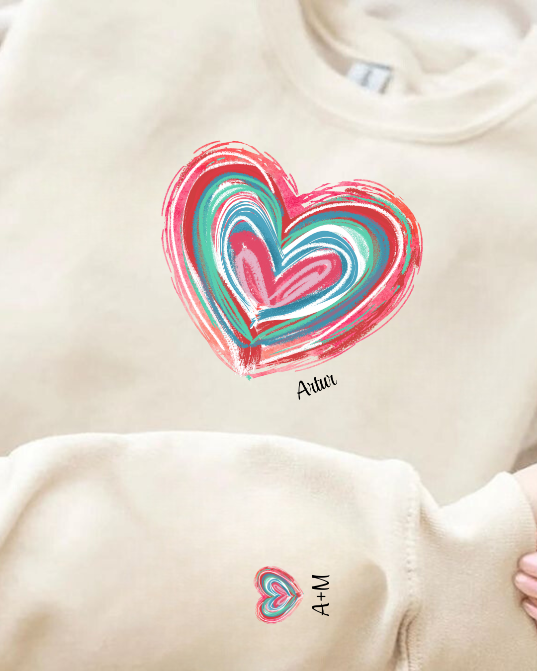 Conjunto de roupa bege com corações coloridos e texto Atriu e A+M