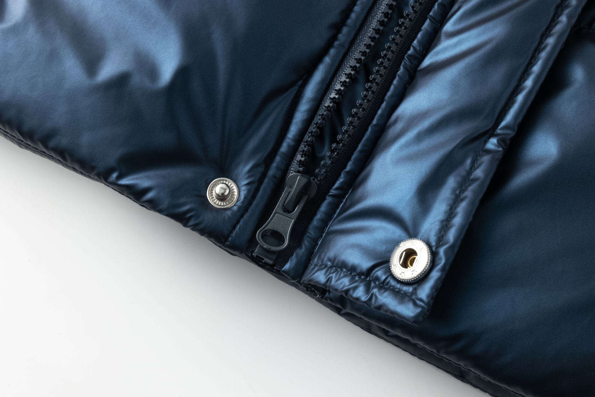 Fecho de correr e botões metálicos em tecido azul escuro brilhante