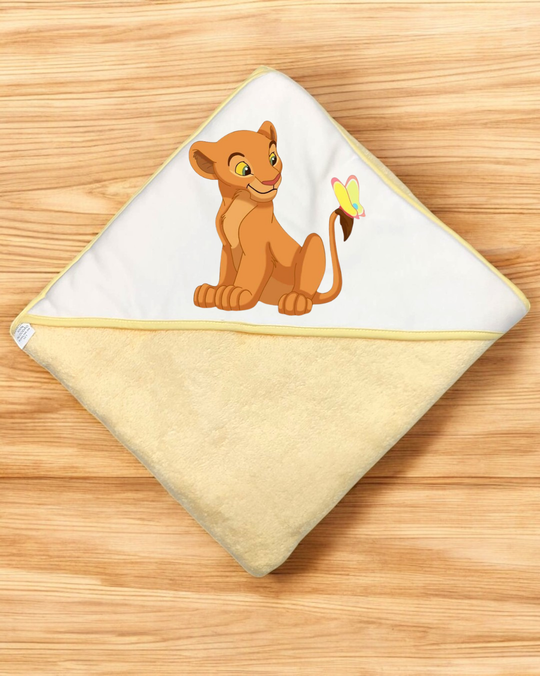 Toalha de banho para bebé amarela com capuz branco e ilustração de leão e borboleta.