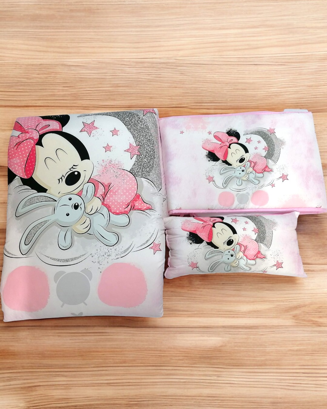 Conjunto de roupa de cama infantil com estampa da Minnie Mouse a segurar um coelho.