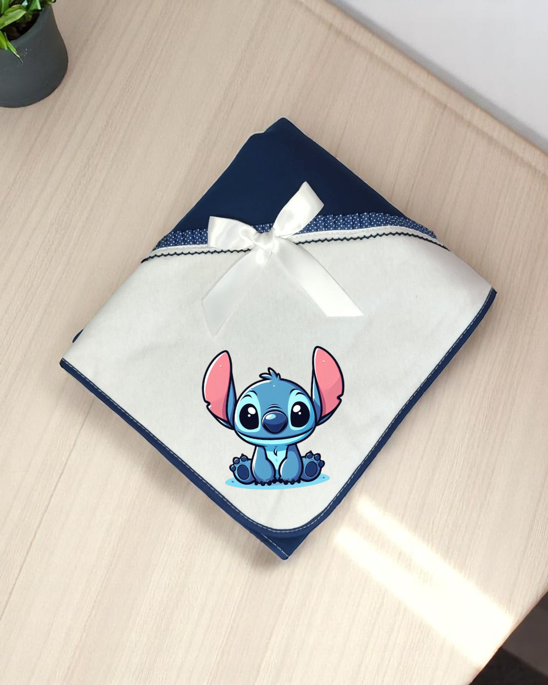 Manta branca e azul com laço branco e personagem Stitch