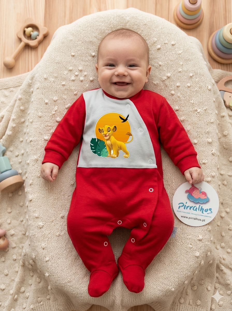 Bebé com body vermelho e branco com estampa de leão amarelo, deitado numa manta bege com brinquedos de madeira