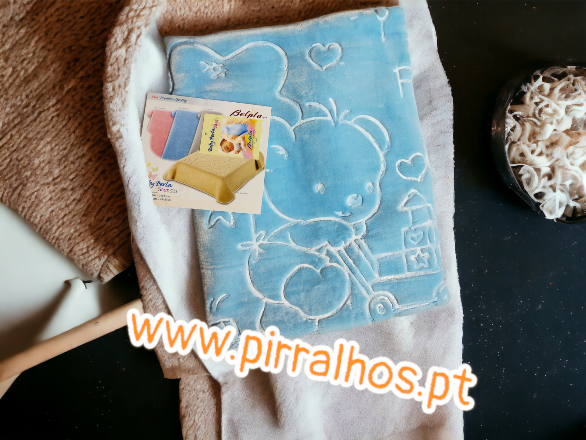 Mantinha azul clara com desenho de ursinho e embalagem de esponja amarela.