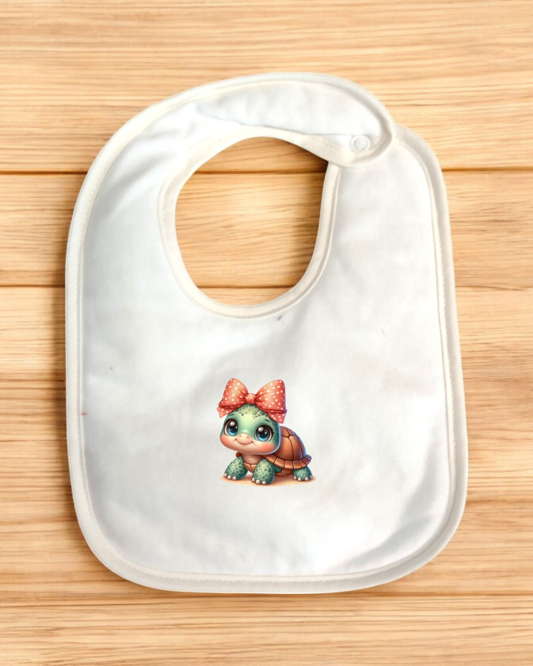 Babete branco com desenho de tartaruga e laço vermelho