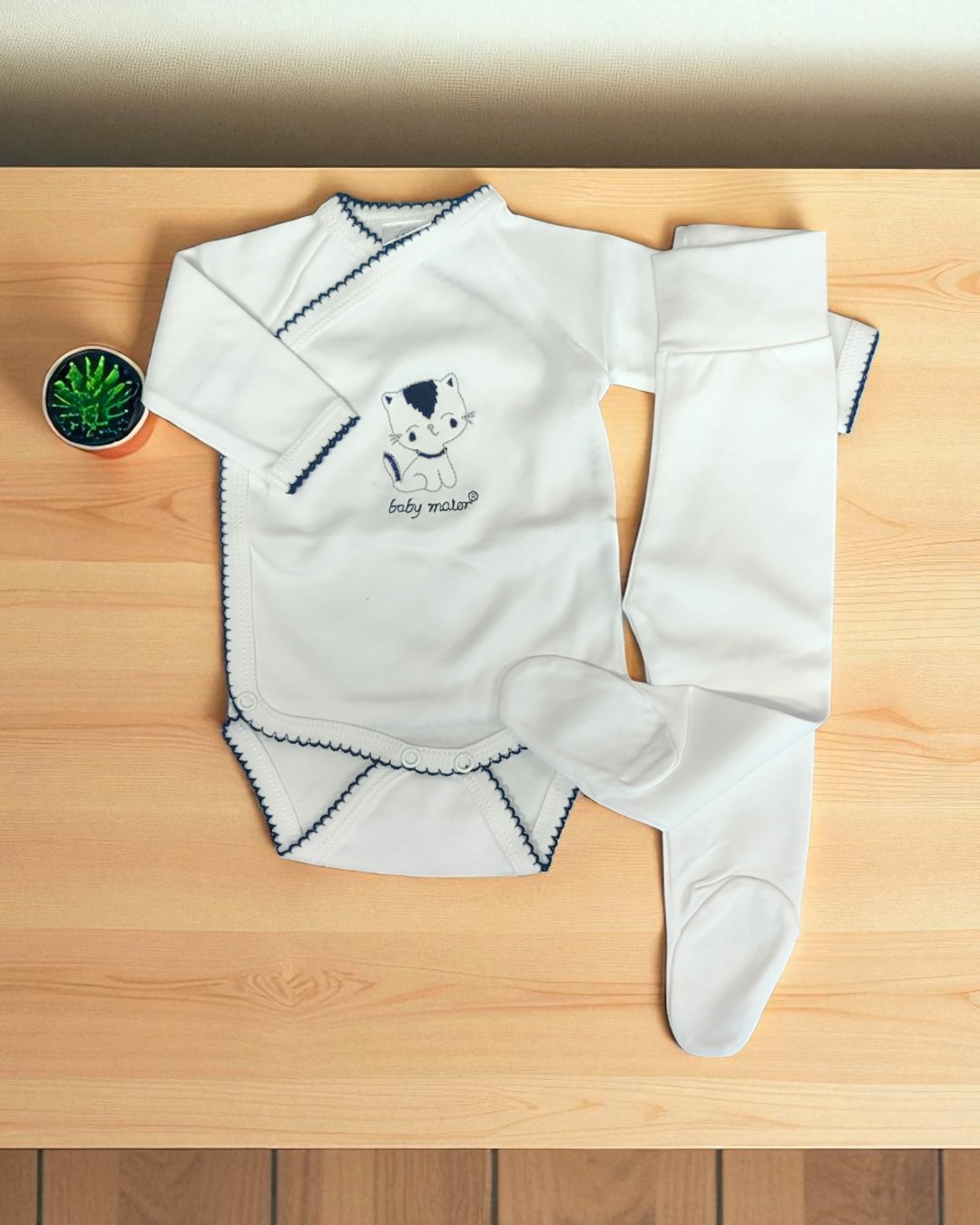 Conjunto de roupa de bebé branco com bordas azul-escuras e desenho de gato