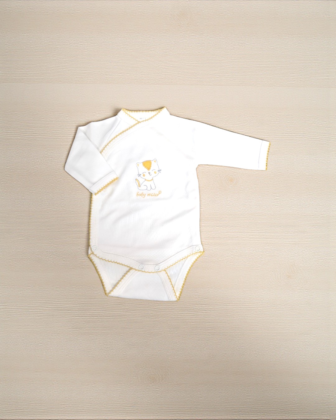Body de bebé branco com bordas amarelas e desenho de gato
