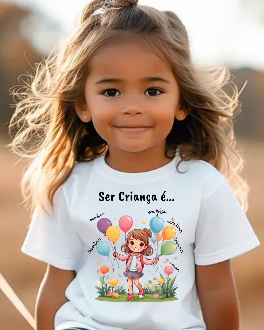 Camisola branca infantil com estampa colorida de menina e balões com texto em português.