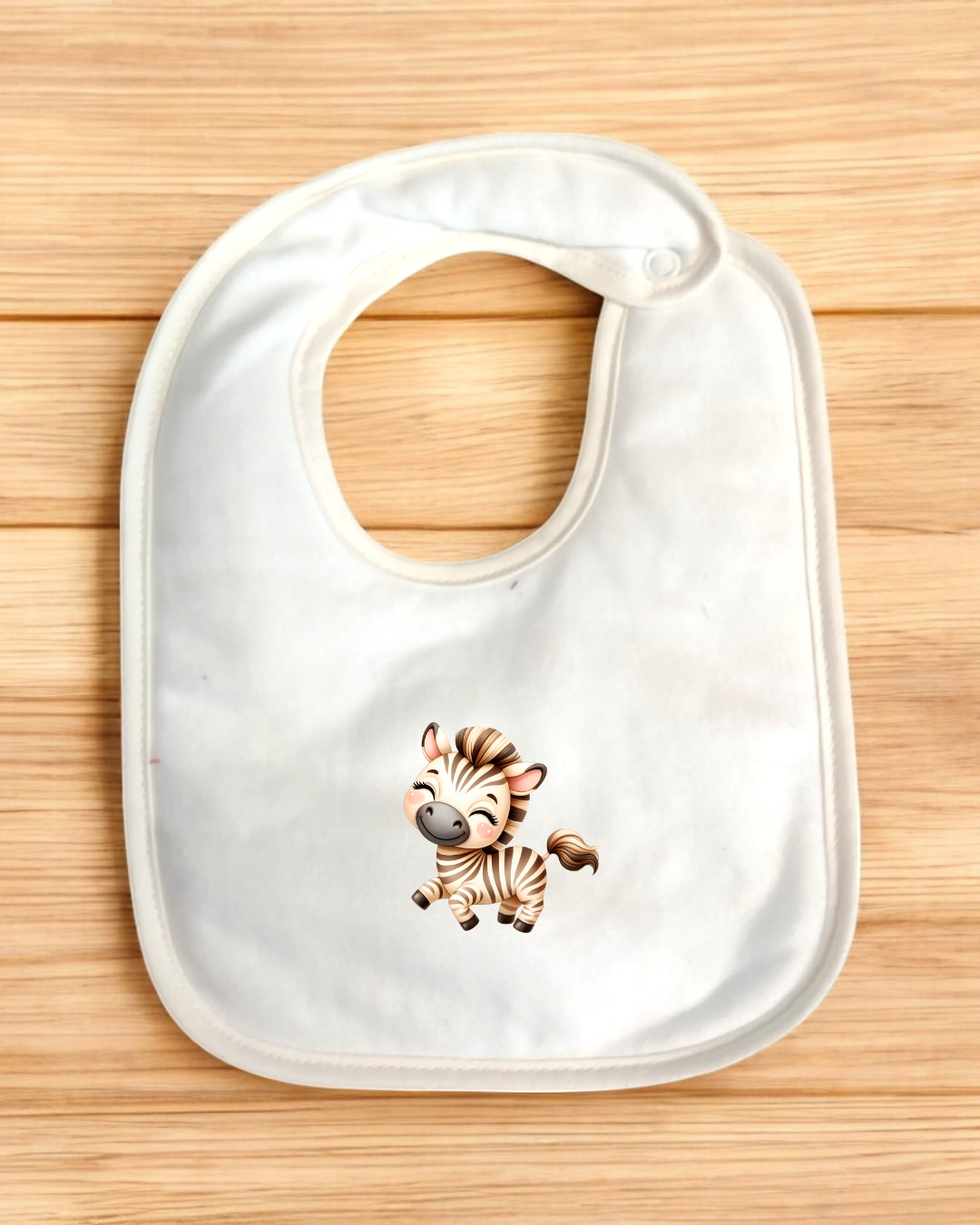 Babete branco com estampa de zebra bebé sobre fundo de madeira