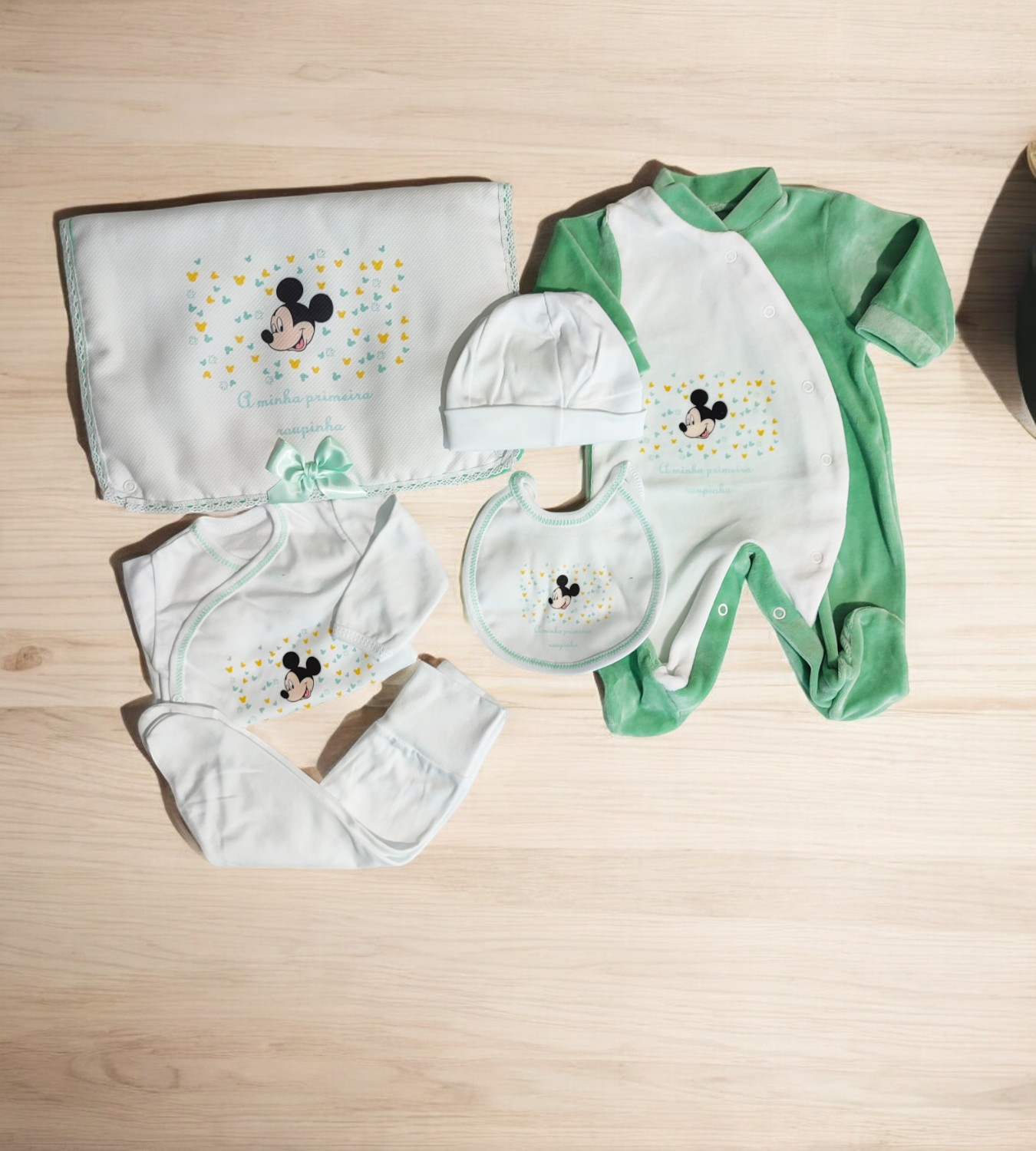 Conjunto de roupa de bebé com padrão do Mickey Mouse em verde e branco.