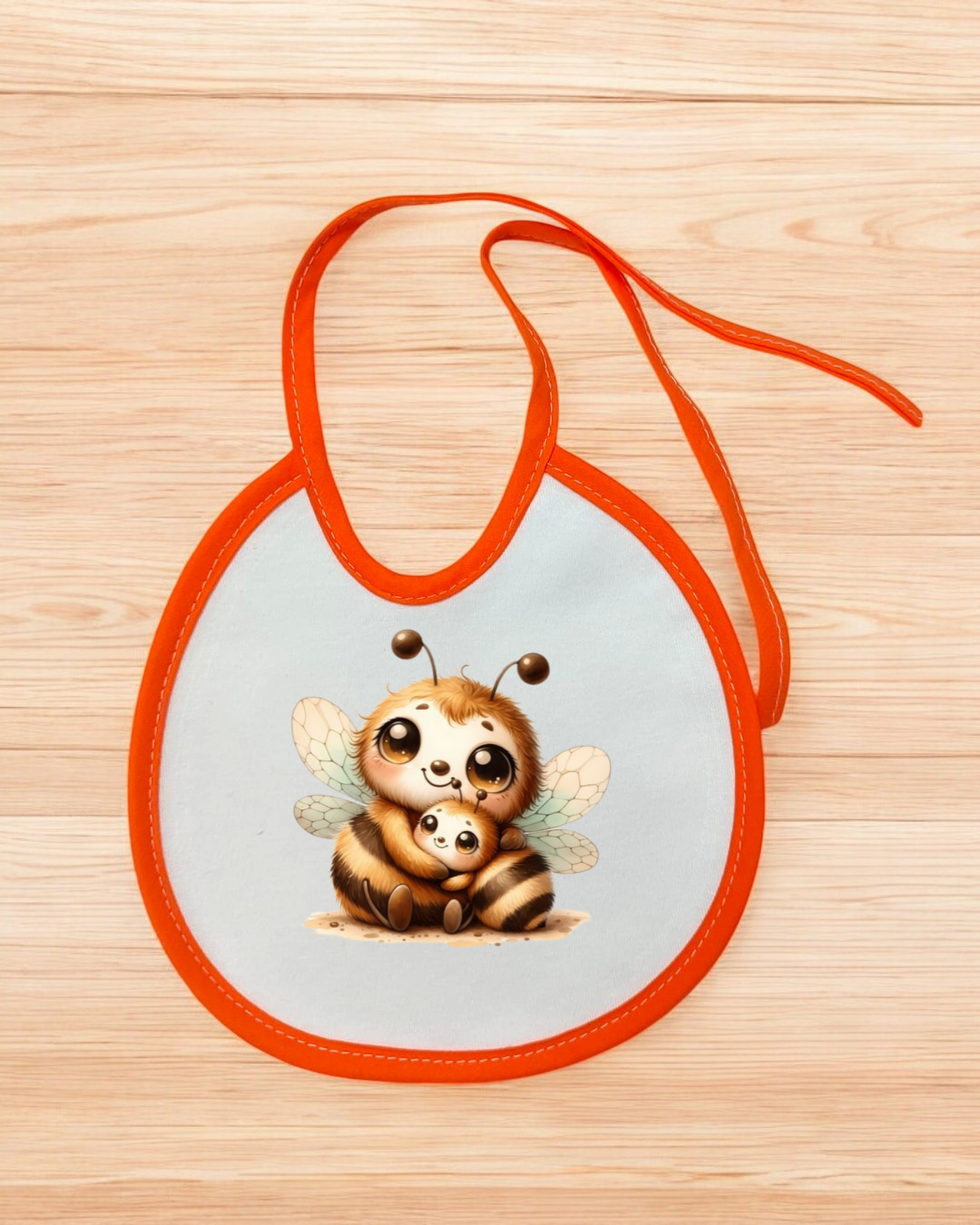 Babete branco com bordas e fita laranja e desenho de duas abelhas.