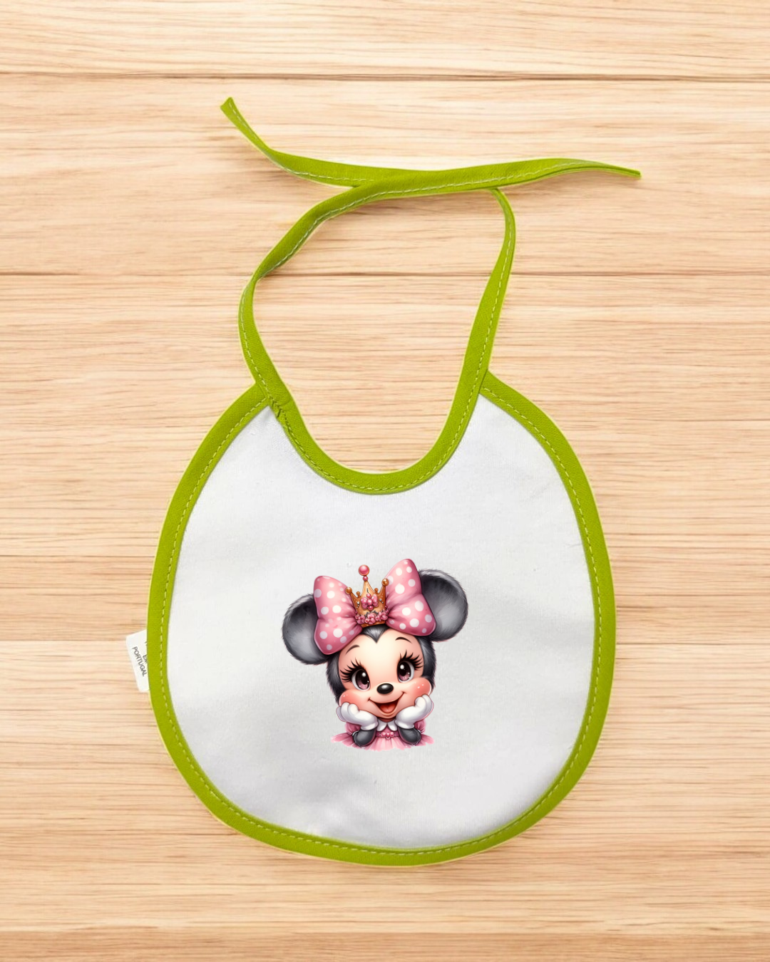 Babete para bebé branco com borda verde e personagem de laço rosa e coroa