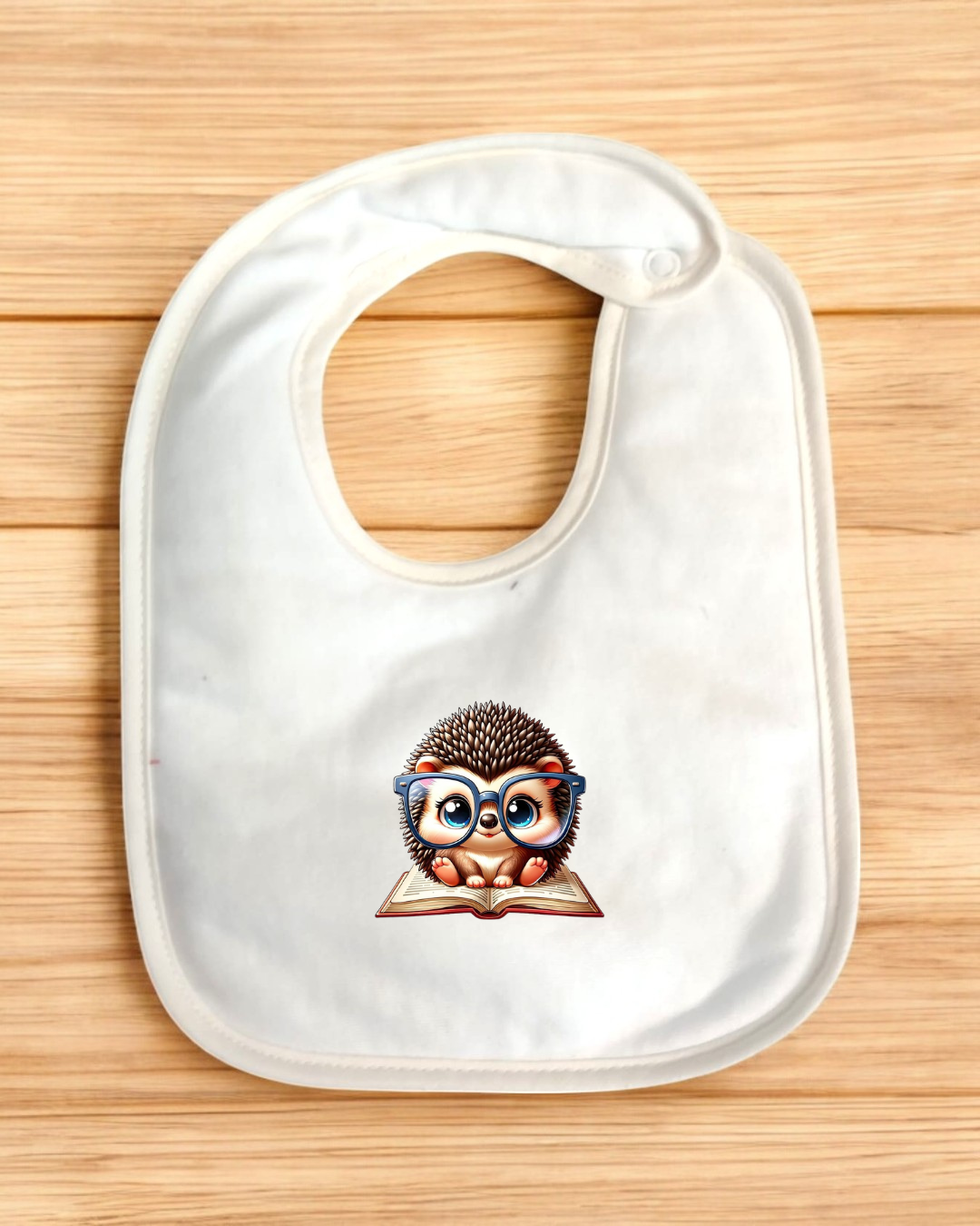 Babete branco para bebé com ilustração de ouriço com óculos a ler um livro