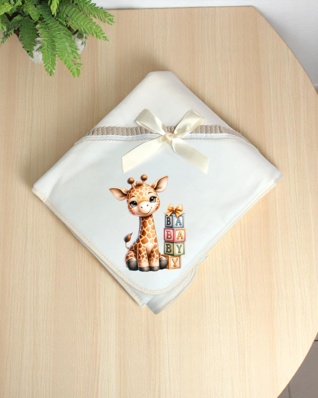 Manta de bebé branca com desenho de girafa e blocos com letras BABY
