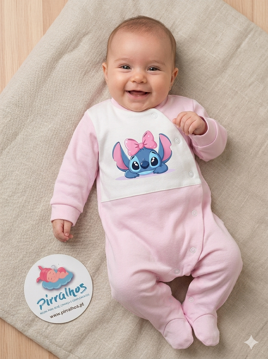 bebé sorridente com macacão rosa e branco com estampa de personagem azul e laço rosa deitado em tecido bege