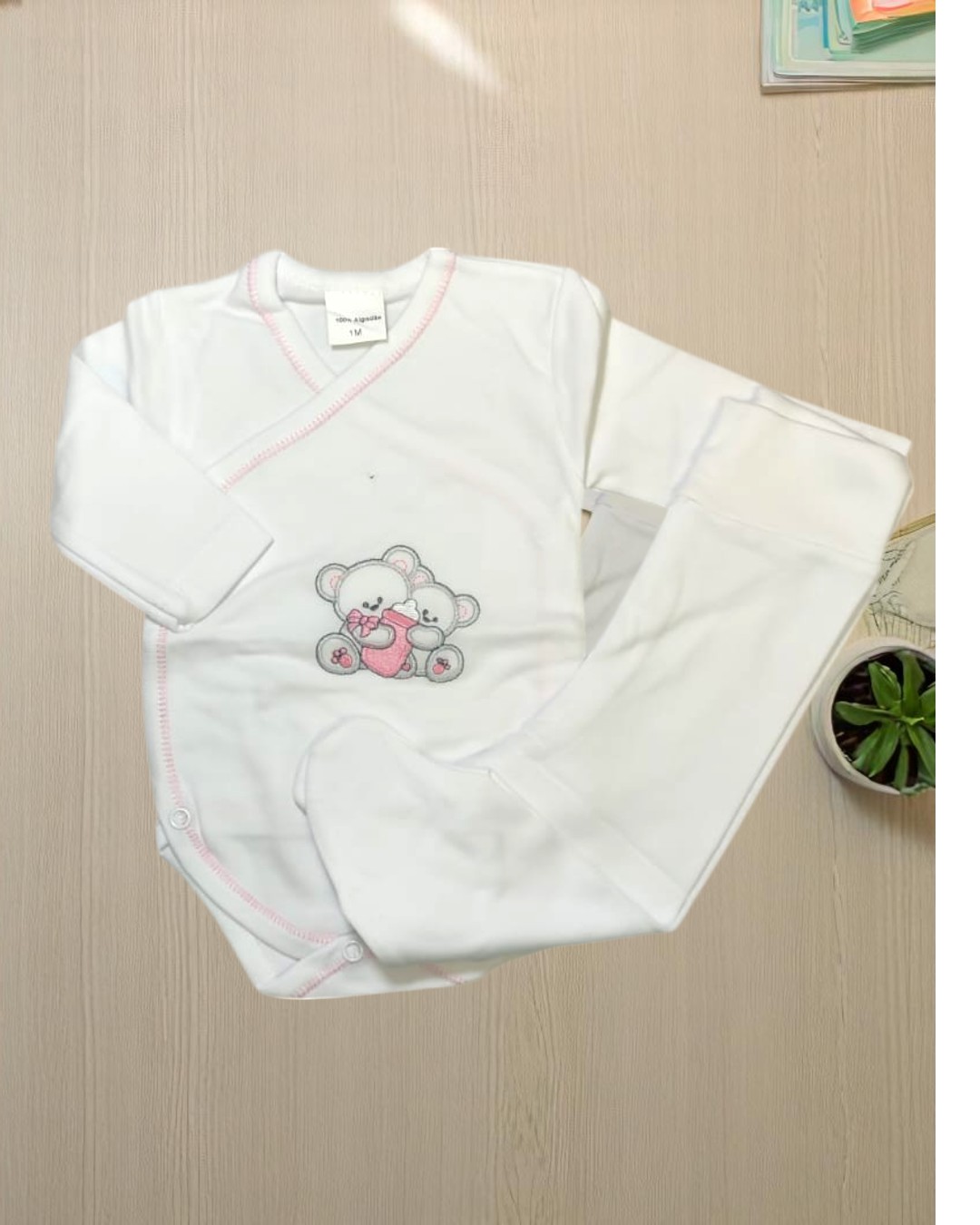 Conjunto branco de roupa de bebé com desenho de ursos e detalhes em rosa