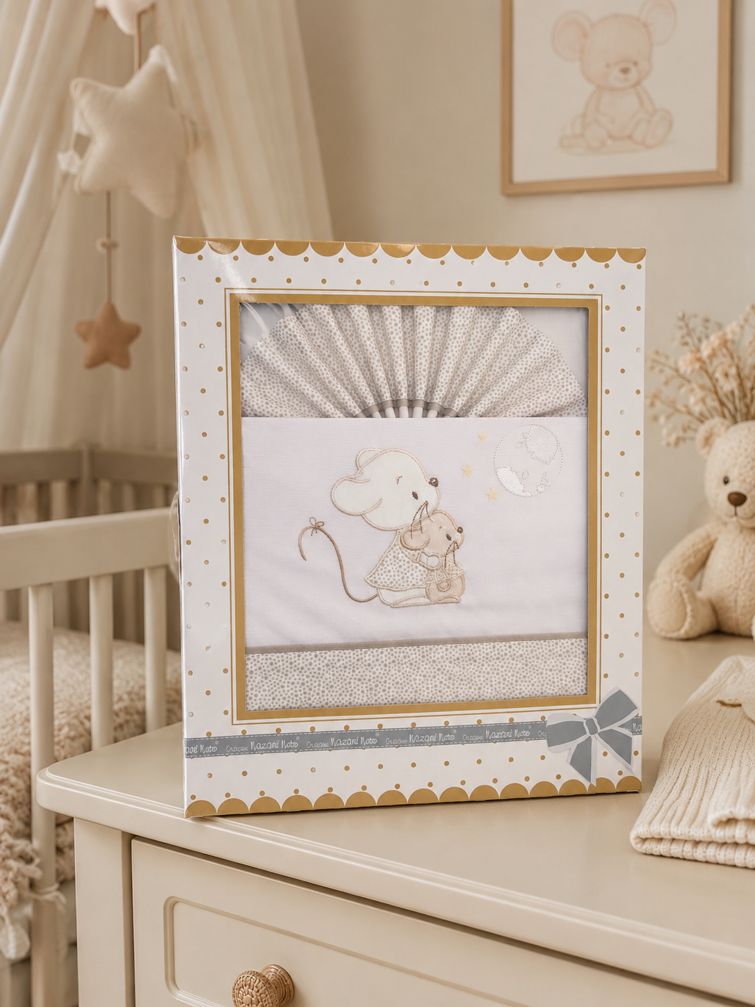 Conjunto de têxteis para bebé em embalagem com motivo de ratinhos e detalhes dourados.