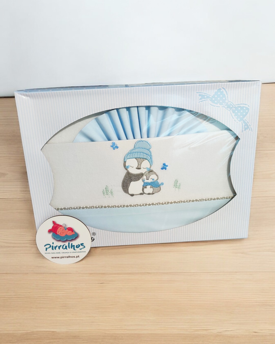 Conjunto de cama de bebé azul com bordado de pinguins em embalagem branca decorada