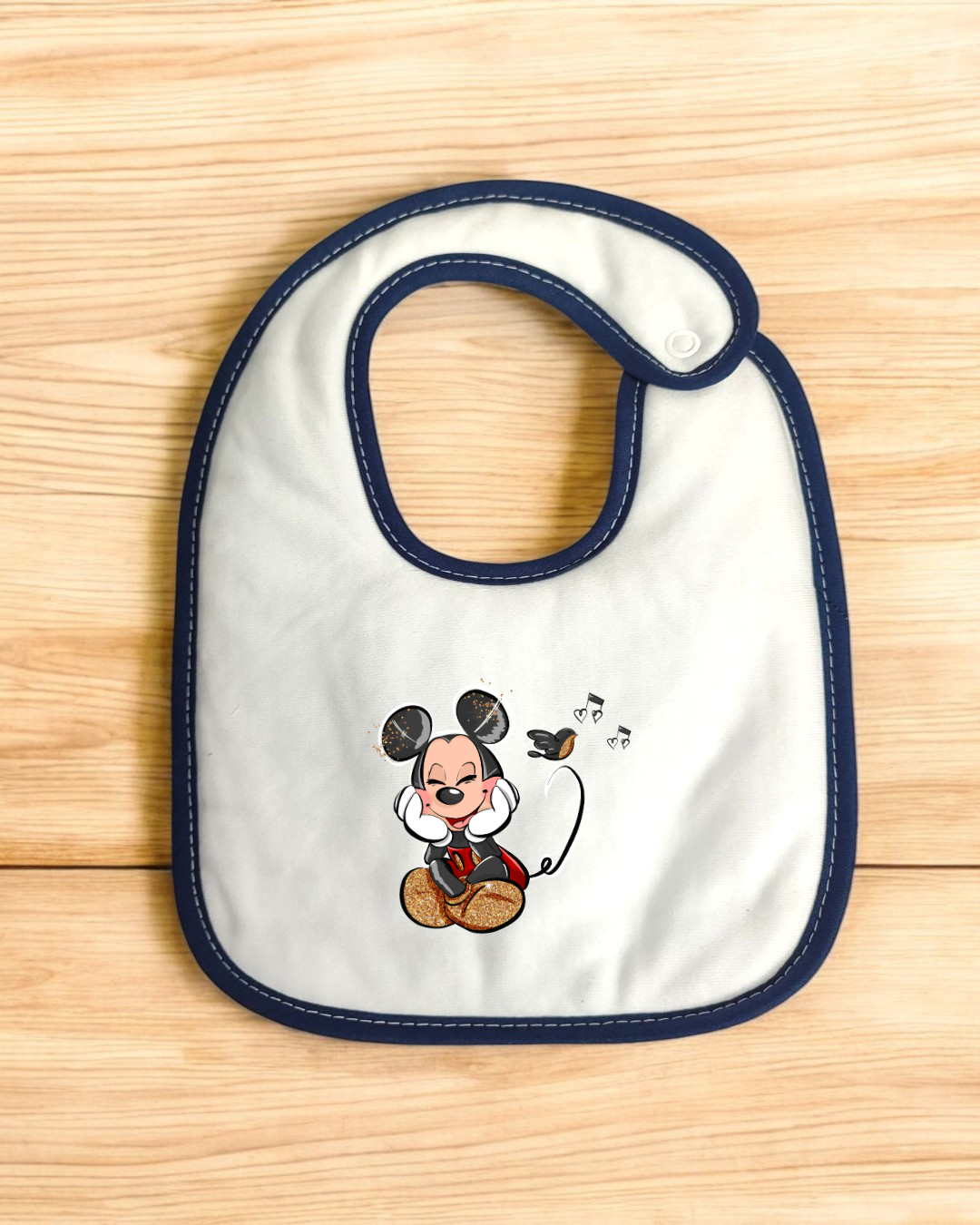 Babete de bebé branco com bordas azuis e desenho de Mickey a ouvir música