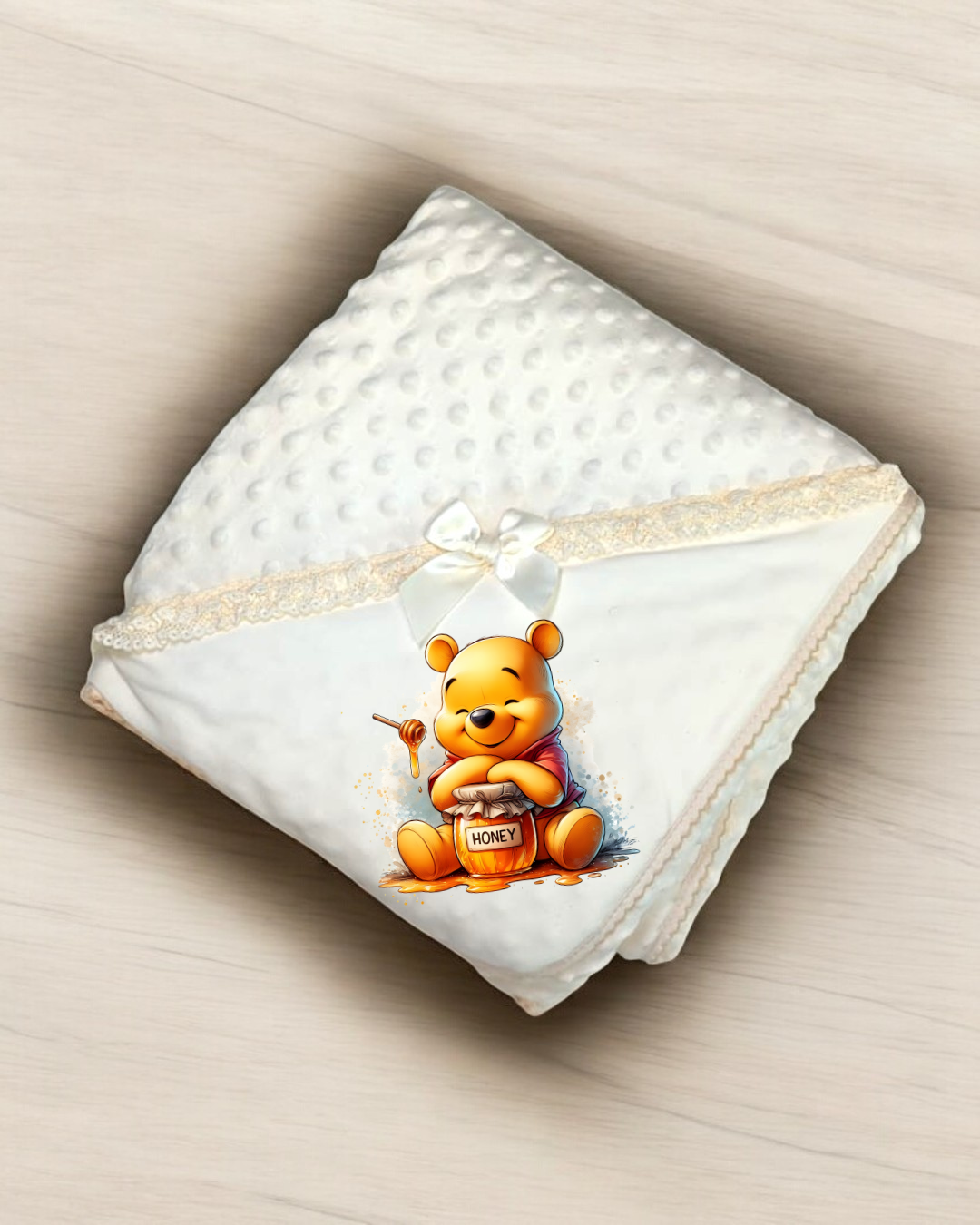 Manta branca com textura e estampagem do Ursinho Pooh com pote de mel