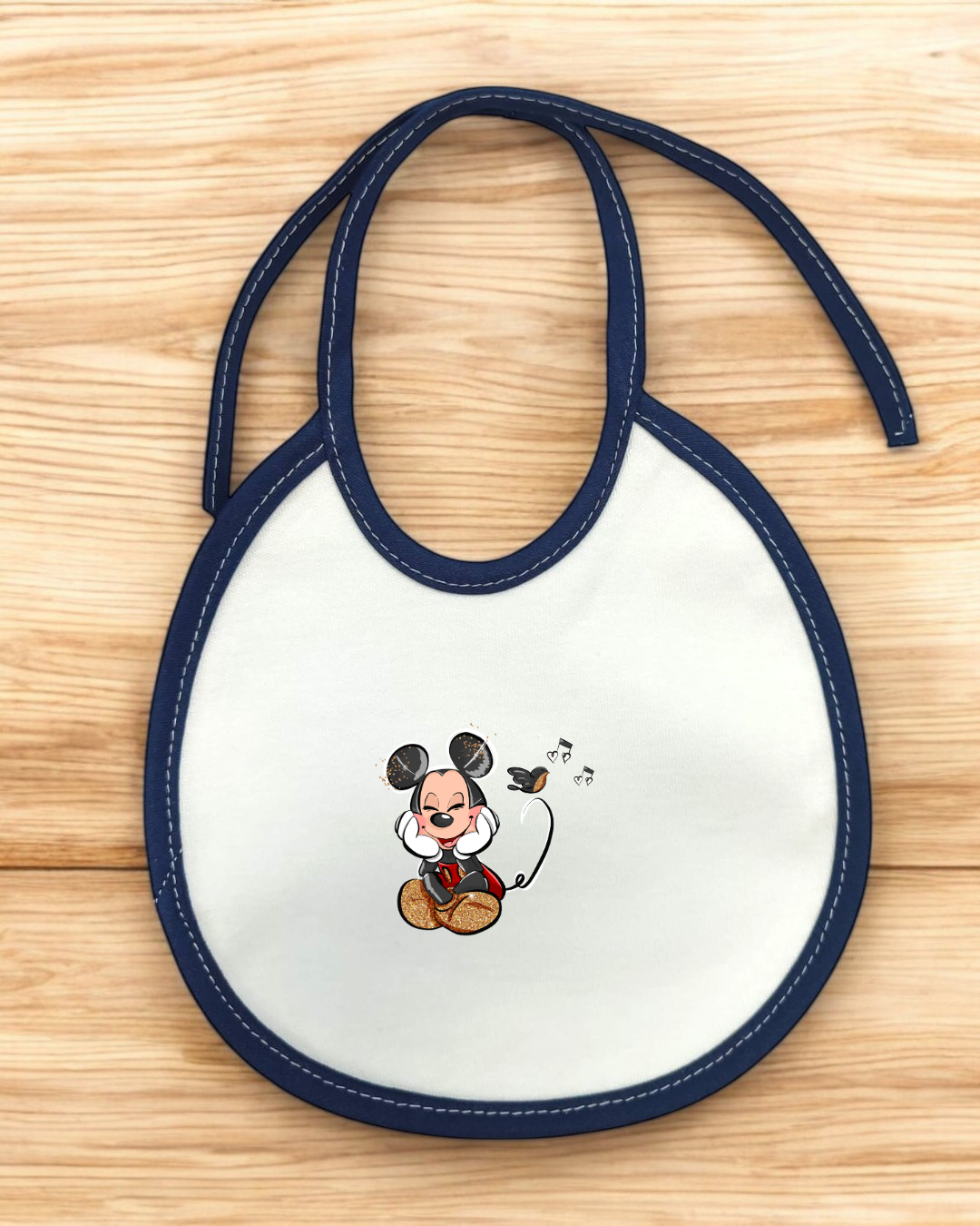 Babete branco com borda azul e desenho do Mickey Mouse