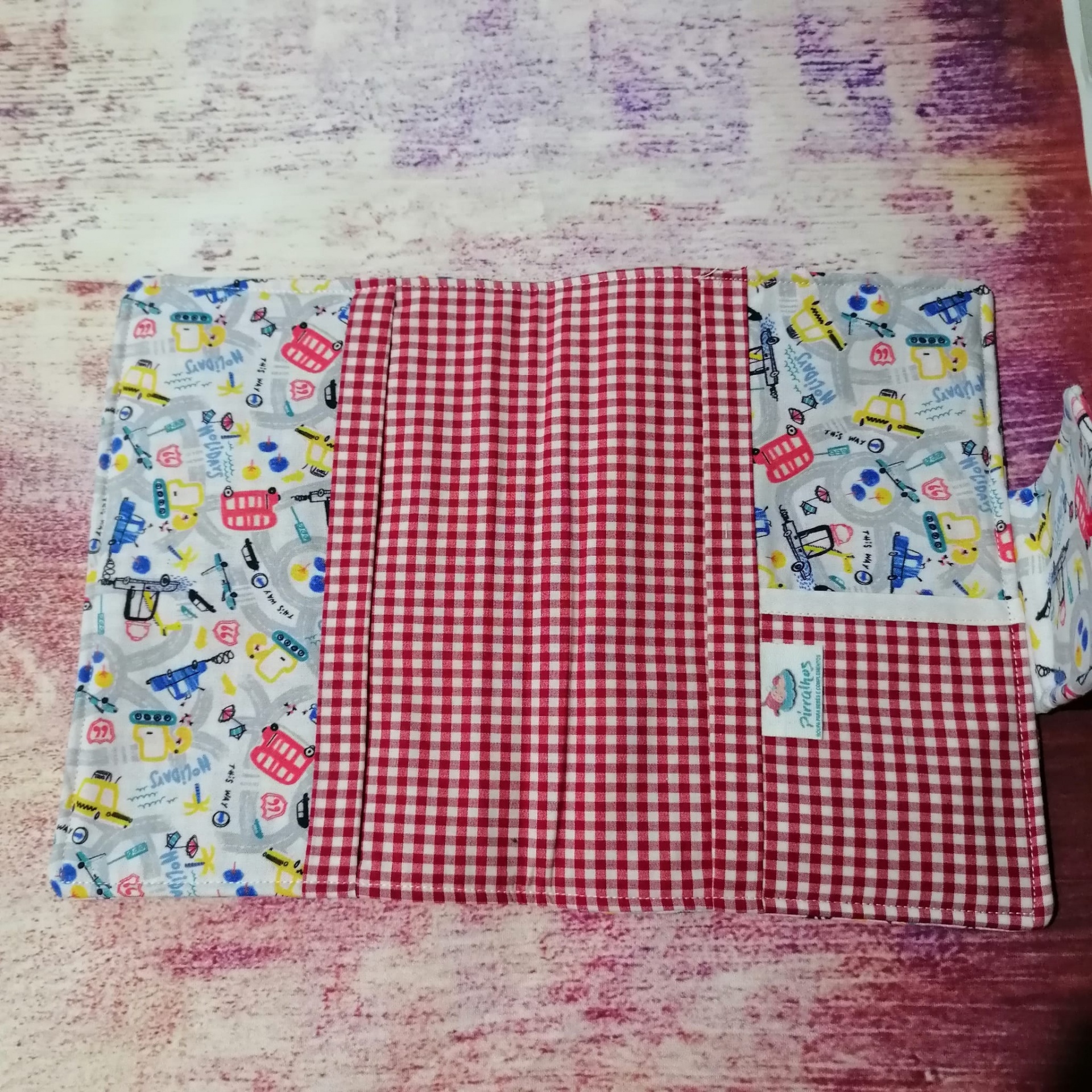 tecido com padrão xadrez vermelho e branco e padrão colorido com desenhos e palavras em fundo branco