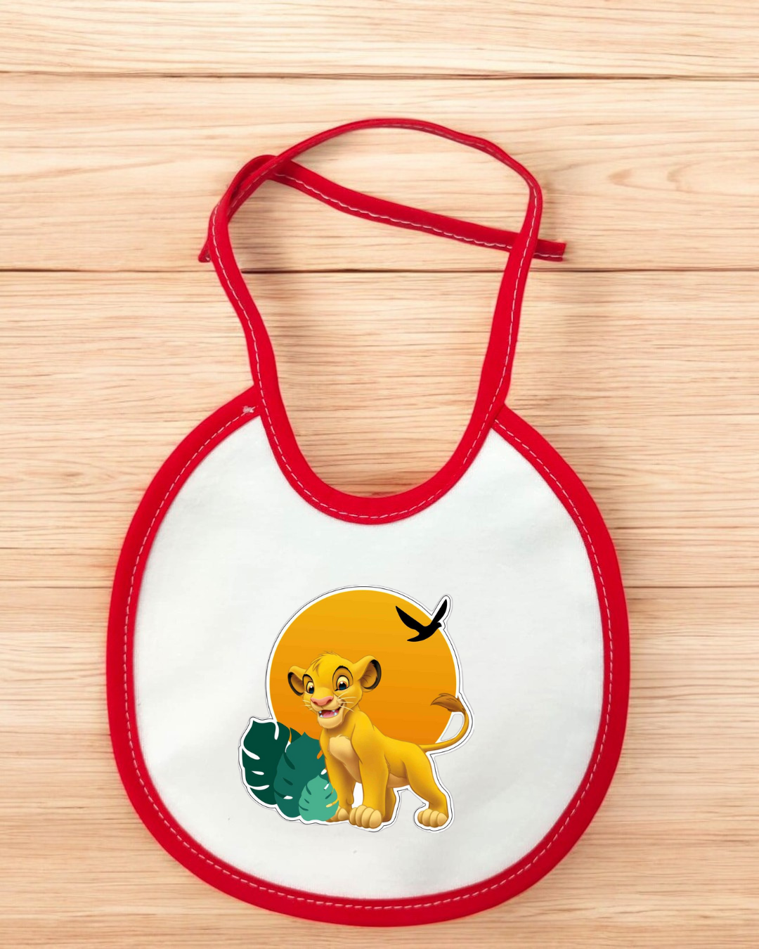 Babete branco com bordas vermelhas e imagem do Simba do Rei Leão