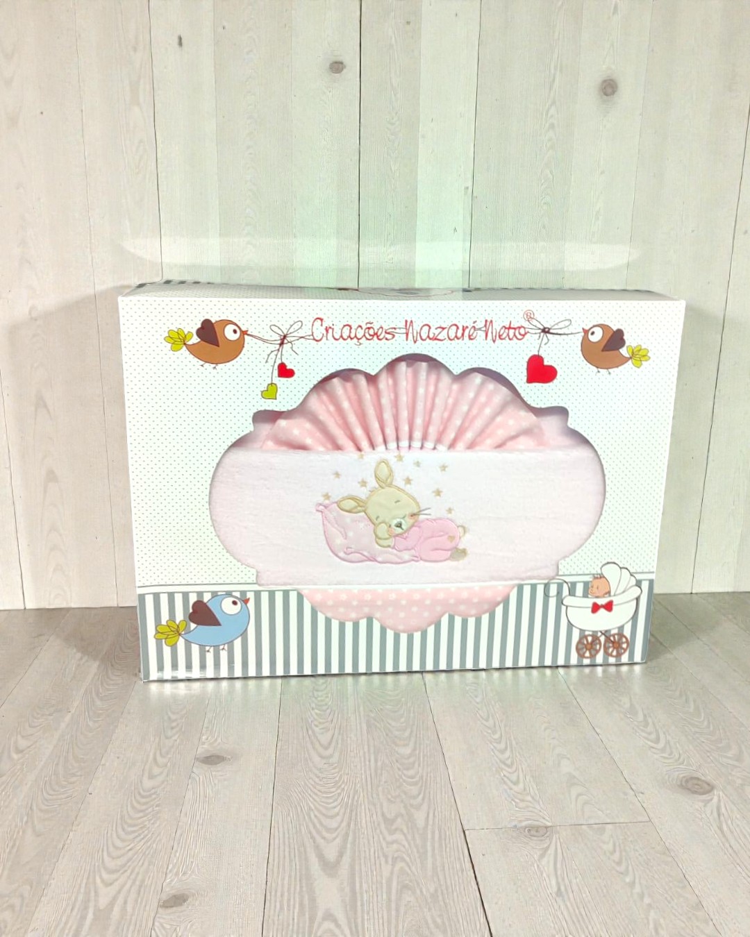 Pacote com tecido rosa e ilustração de coelho, com decoração de pássaros e carrinho de bebé