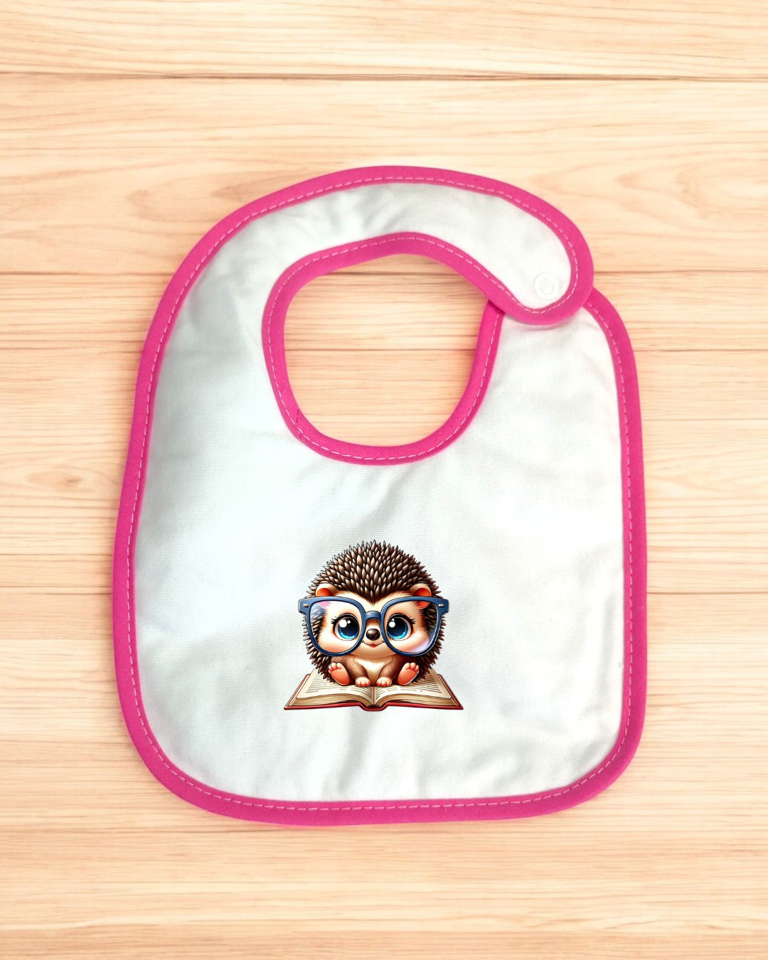 Babete branco com bordas rosa e estampa de ouriço com óculos azuis em livro