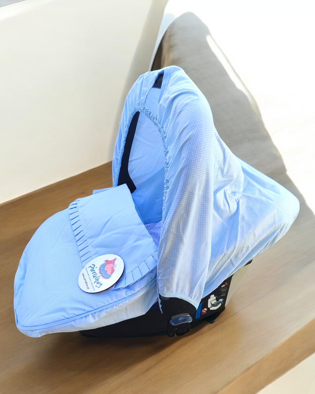 assento de bebé azul claro com tecido riscado e etiqueta Prince & Princess sobre madeira clara