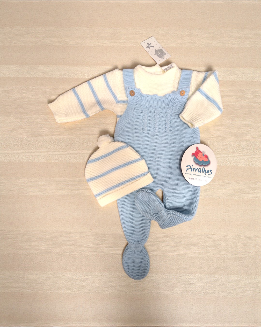 Conjunto de roupa de bebé em malha creme e azul claro com etiqueta Piraínhos