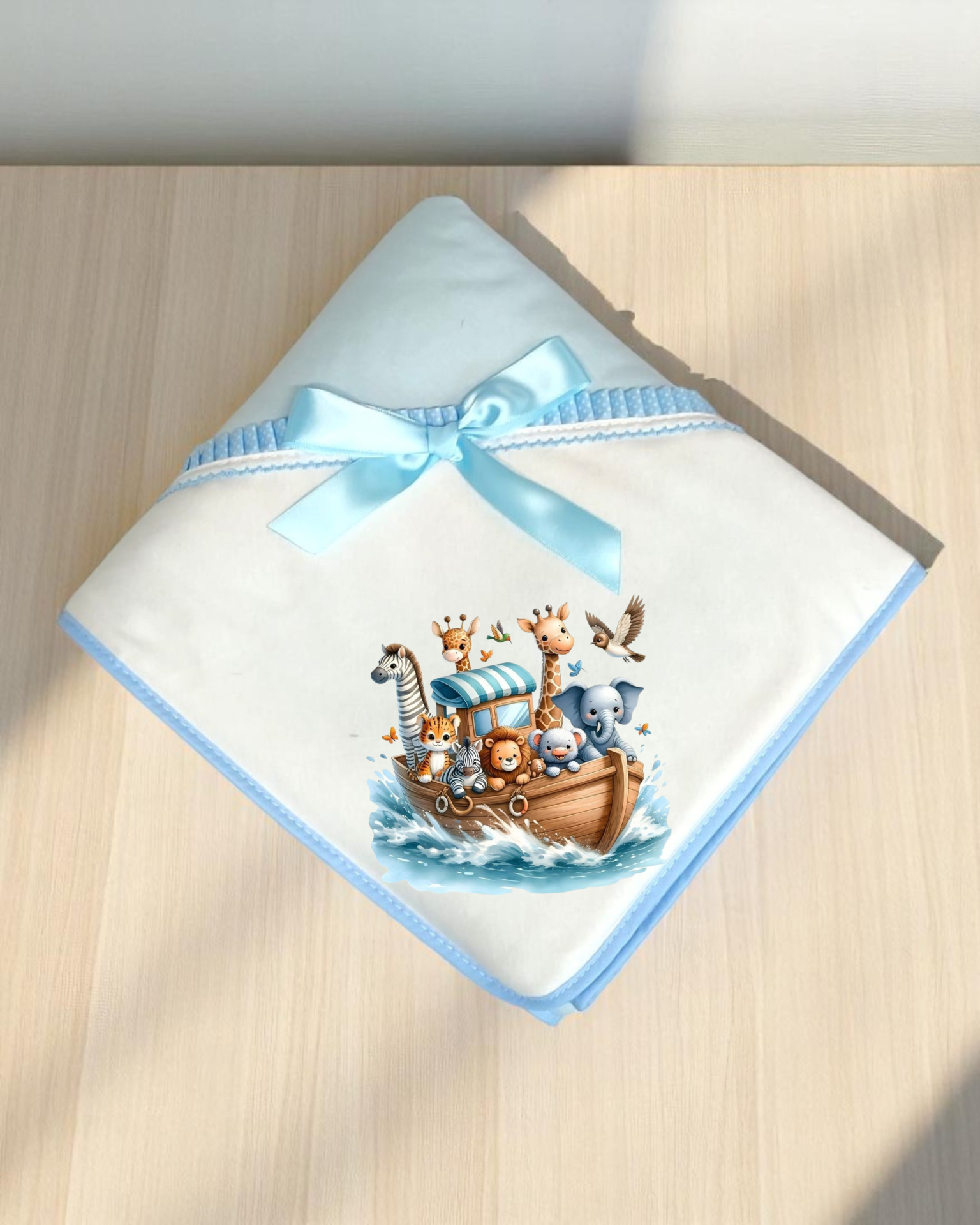 Fralda branca com borda azul e imagem de arca dos animais colorida.