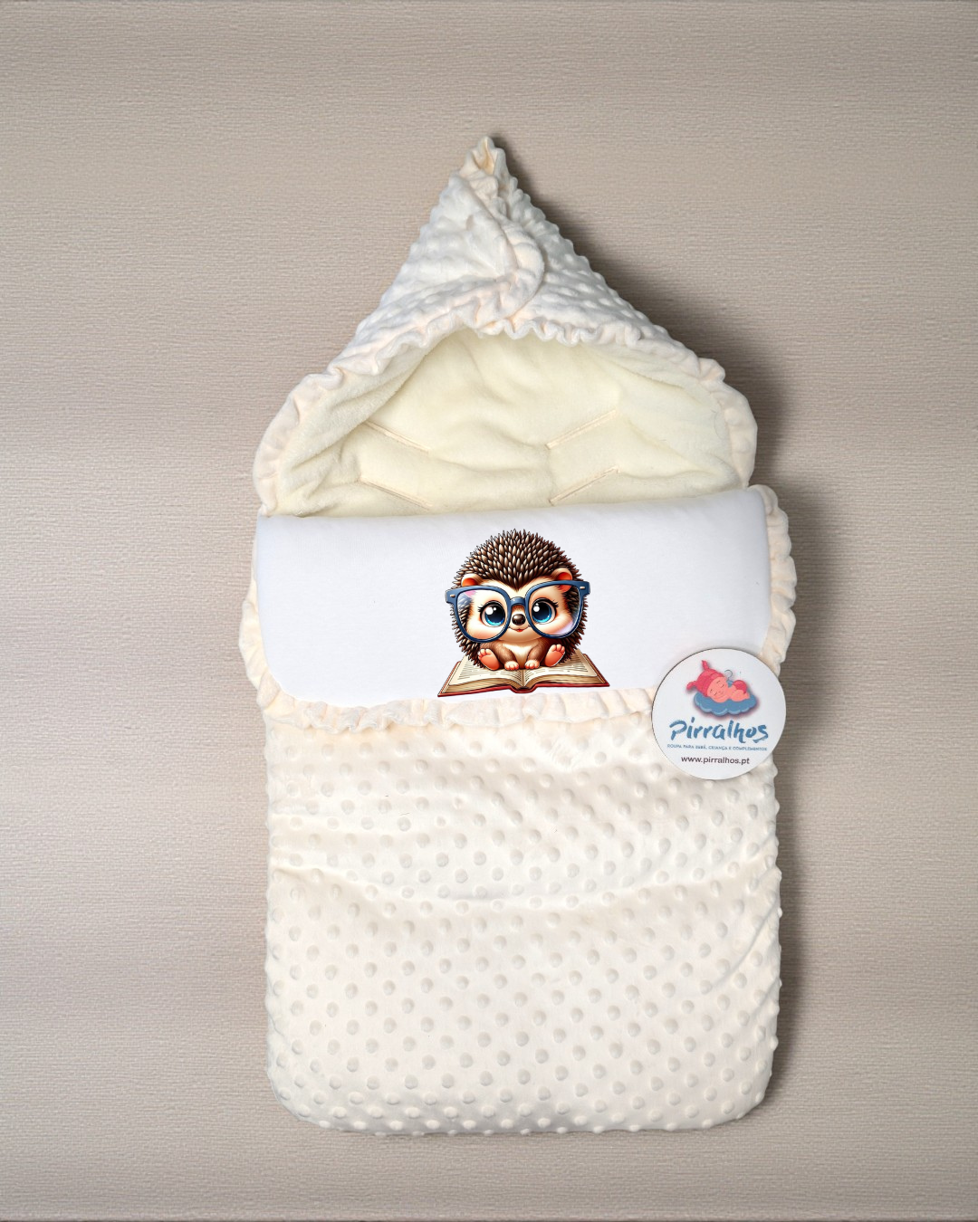 Saco de bebé branco com capuz texturizado e etiqueta da marca Pirralhos