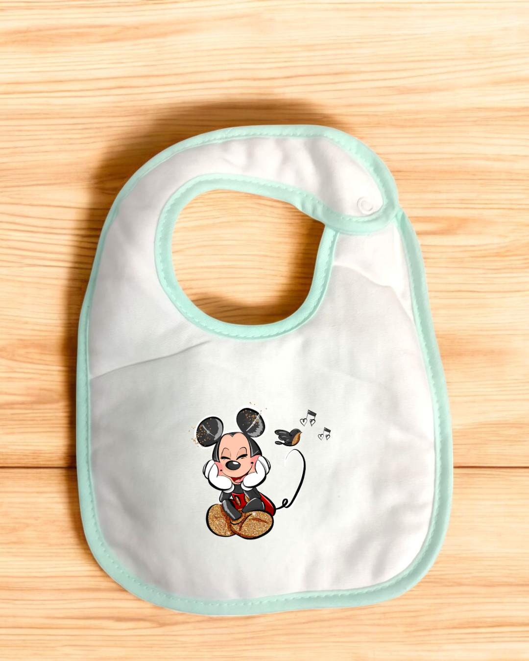 Babete branco com borda verde claro e desenho de Mickey Mouse com passarinho