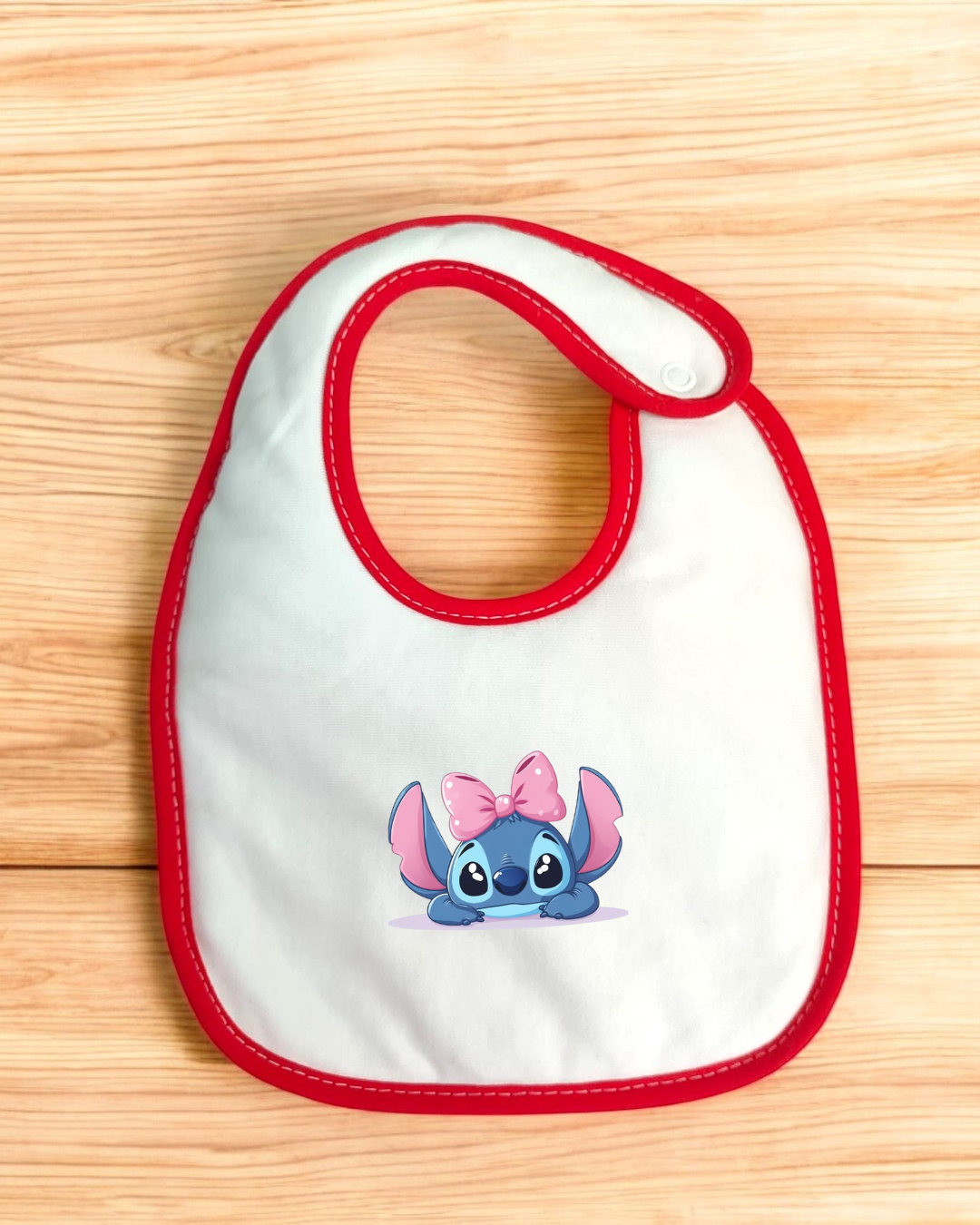 Babete branco com borda vermelha e estampa personagem Stitch com laço rosa