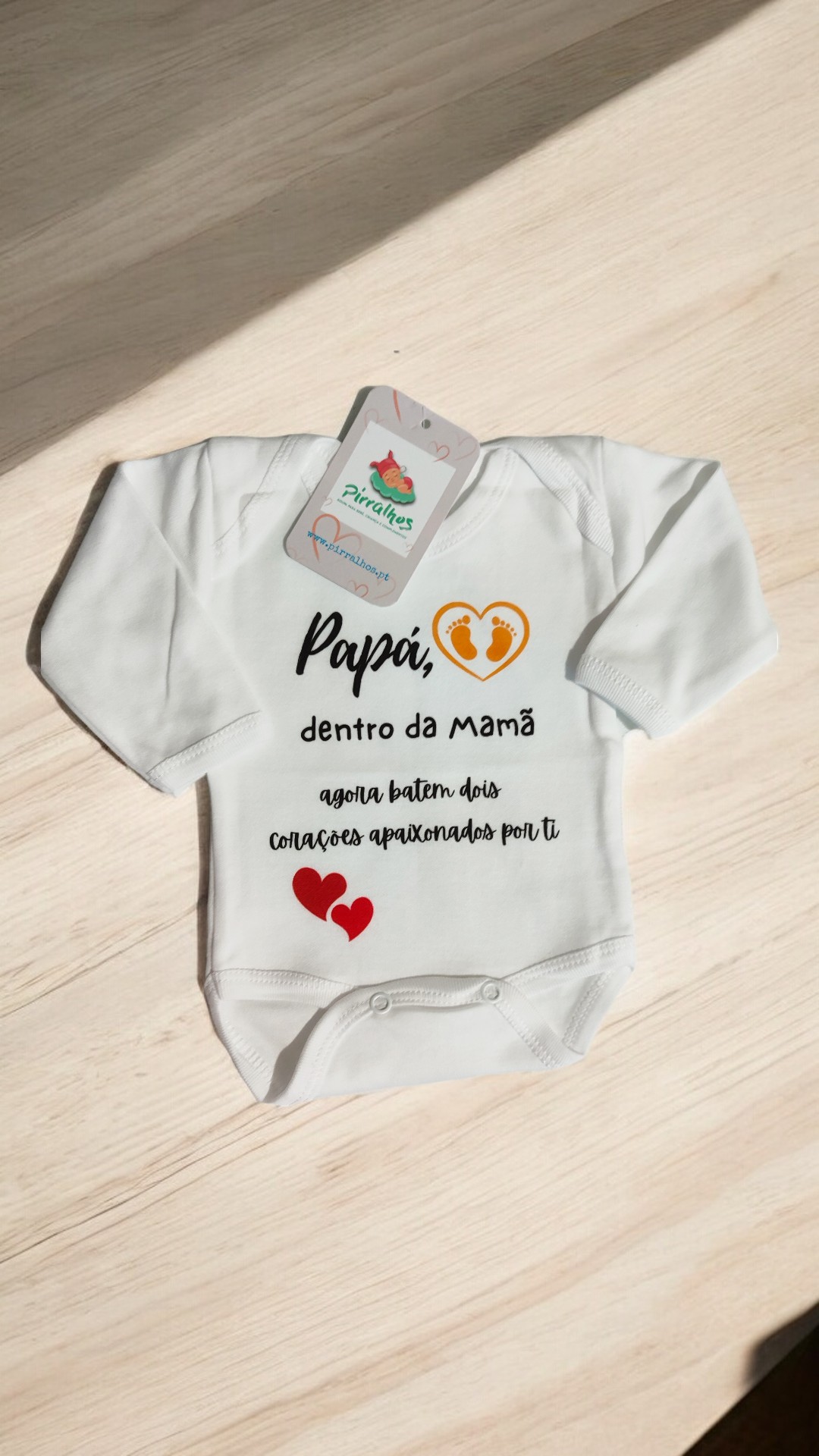 Body branco de bebé com texto e desenhos estampados.
