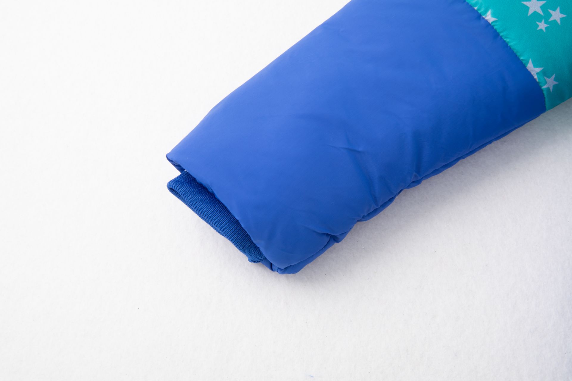 Punho de casaco infantil azul e turquesa com estampado de estrelas