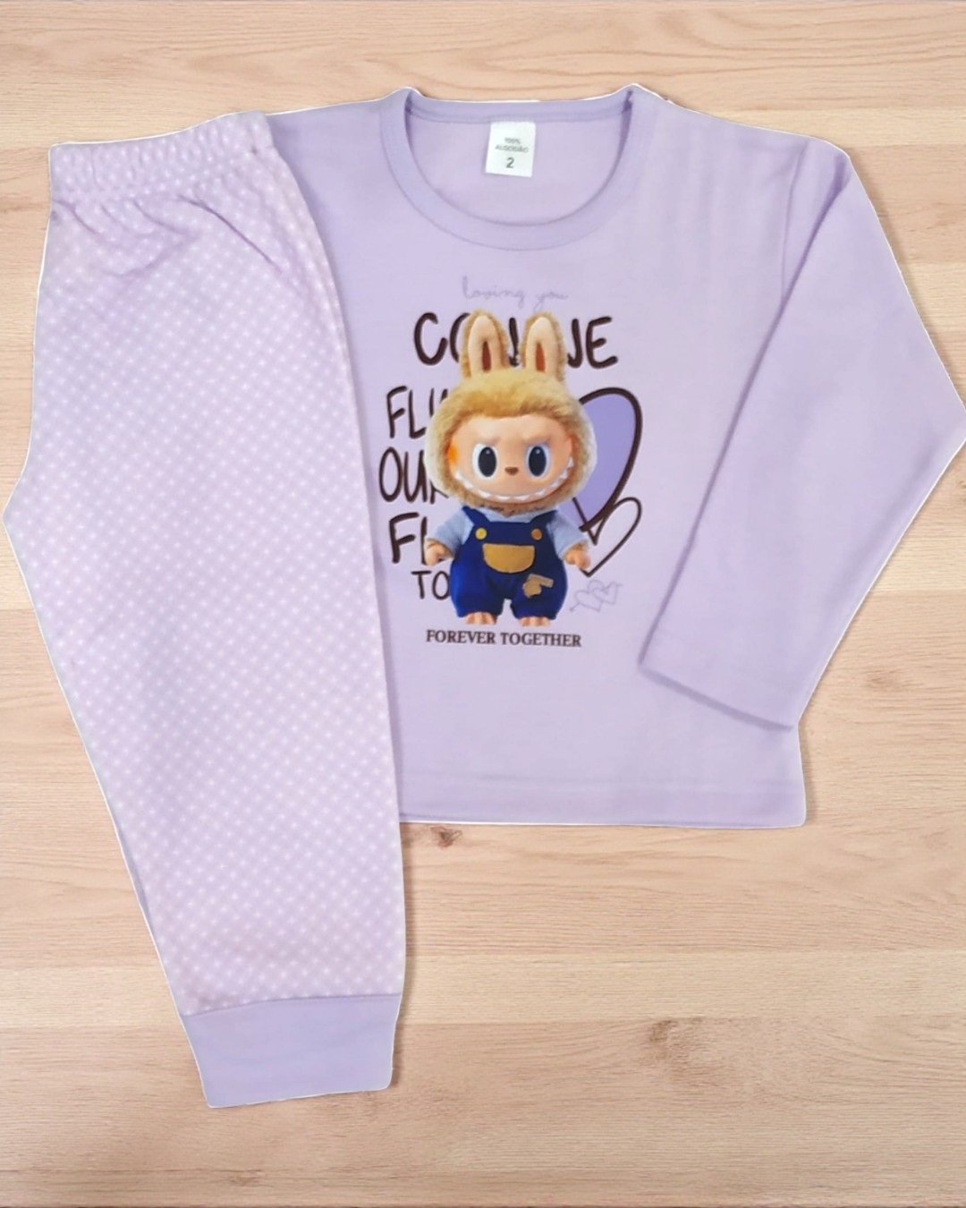Pijama infantil lilás com estampa de coelho 3D e texto, calças com padrão de bolinhas, tecido macio.