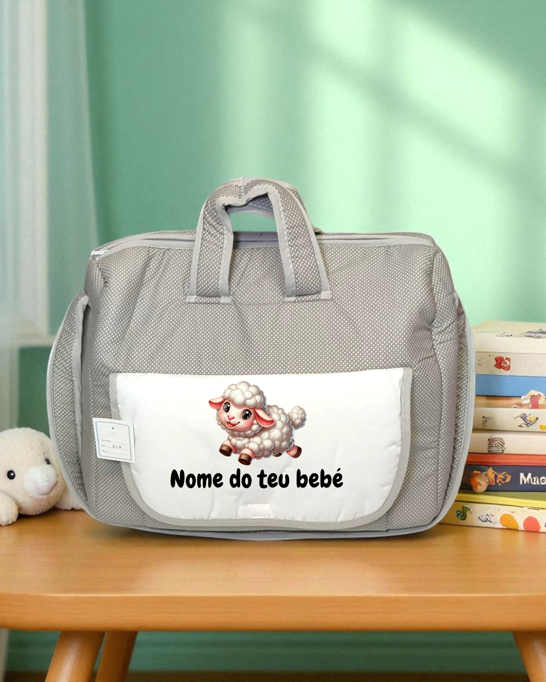 Mala de bebê cinza com bolso frontal branco com desenho de cordeiro e texto em português