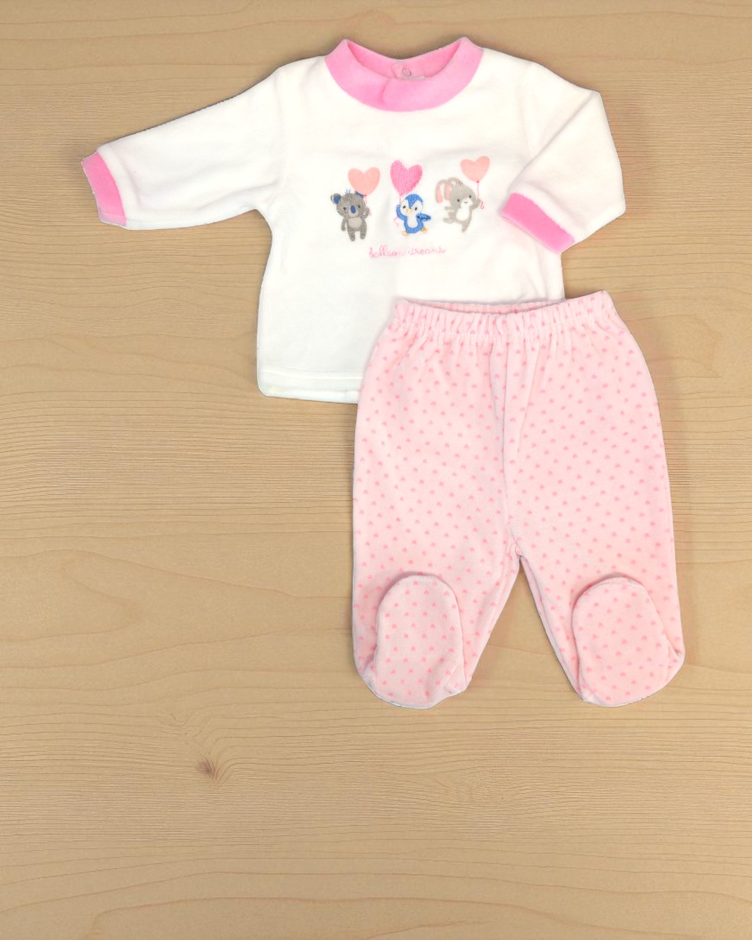 Conjunto bebé com camisola branca e calças cor-de-rosa com padrão de pontos.