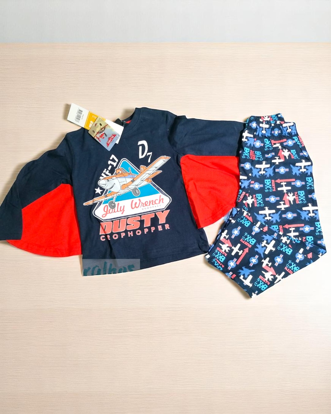 Conjunto de roupa infantil azul escuro com avião e calças com padrão de aviões coloridos