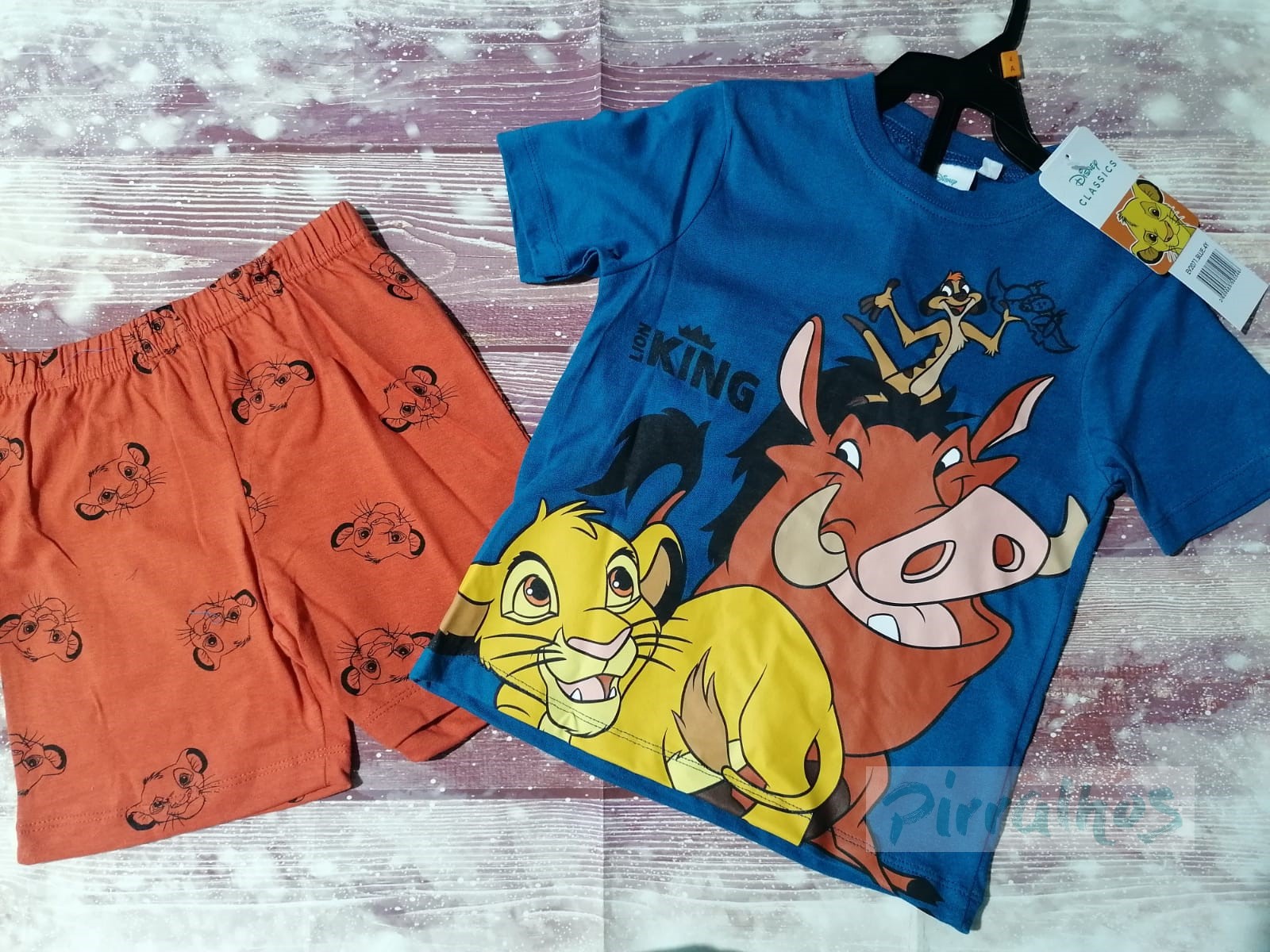 Conjunto infantil de t-shirt azul com personagens do Rei Leão e calções cor de laranja com padrões de Simba.