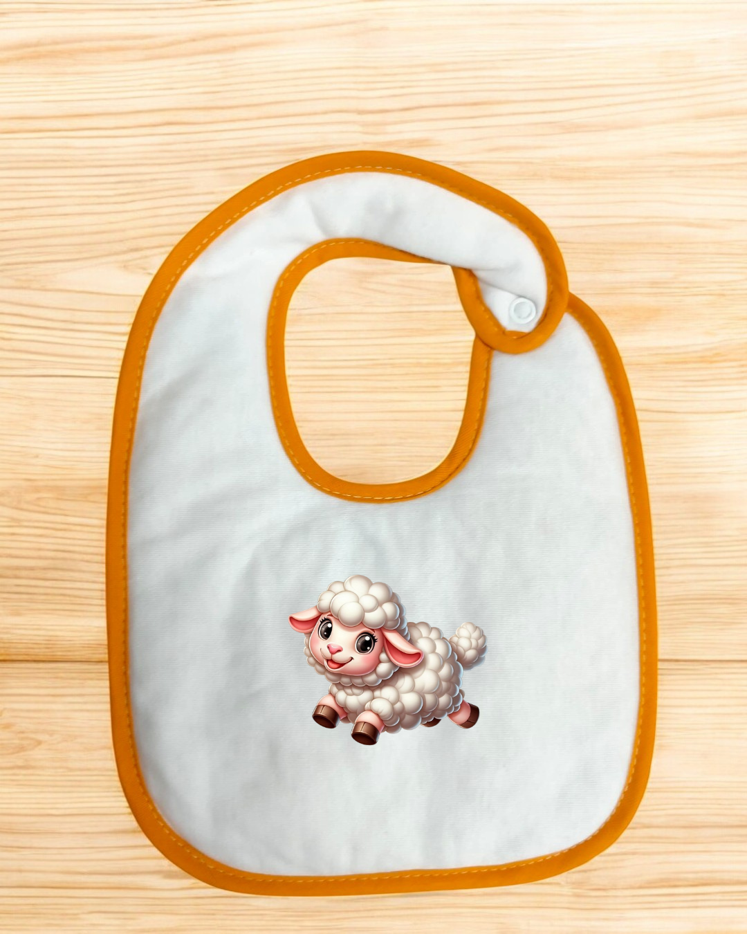 Babete branco com bordas laranja e imagem de carneiro sobre superfície de madeira
