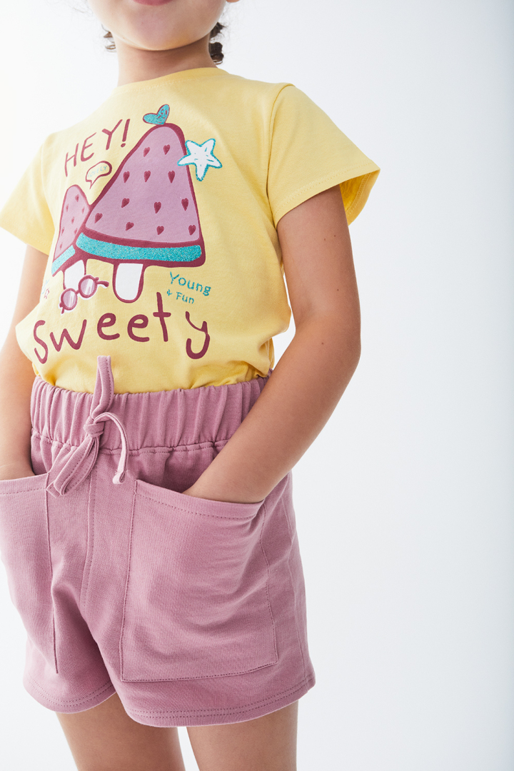 Camisola amarela estampada com calções rosa com bolso e cordão.