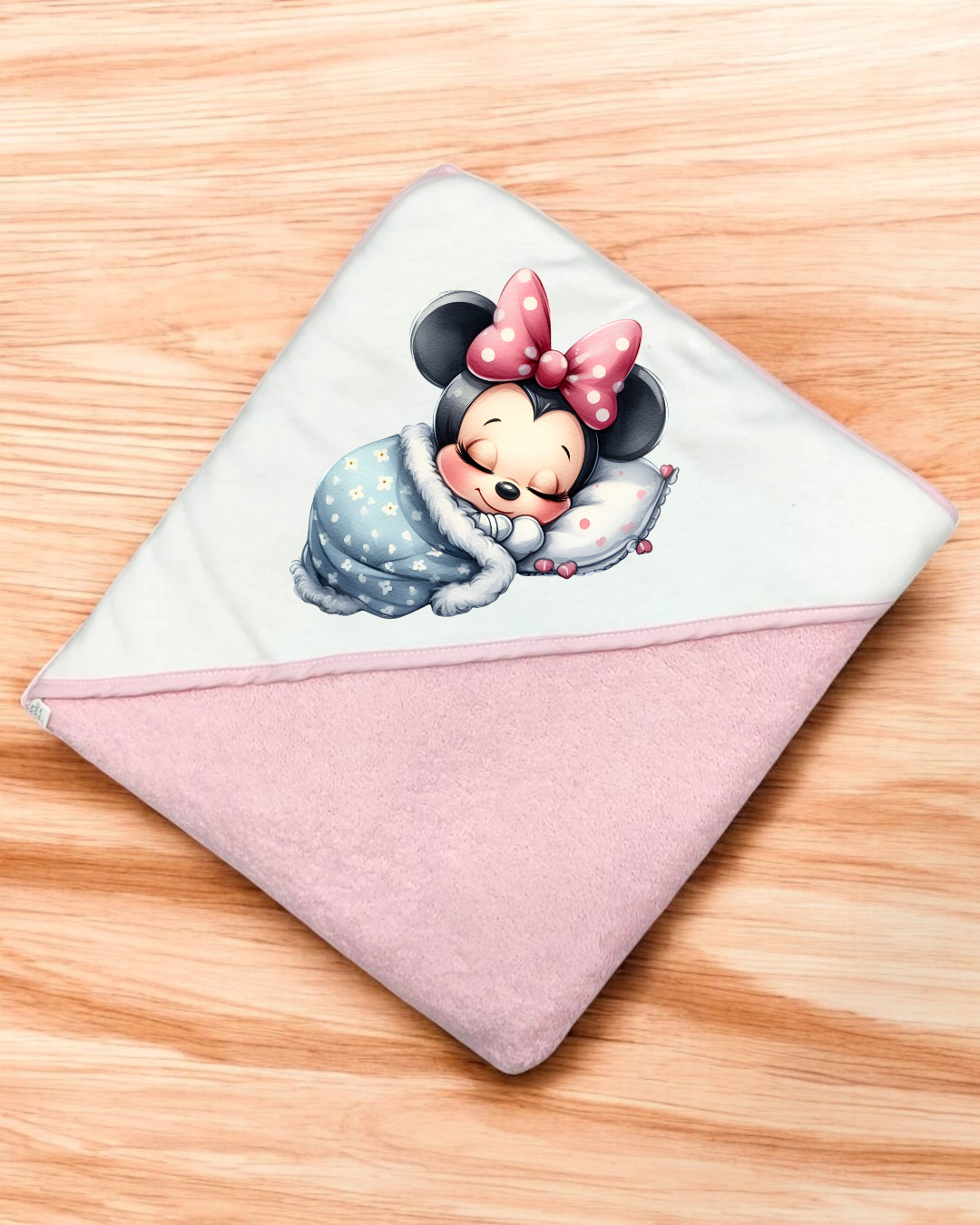 Toalha de banho infantil rosa e branca com imagem da Minnie a dormir e laço rosa