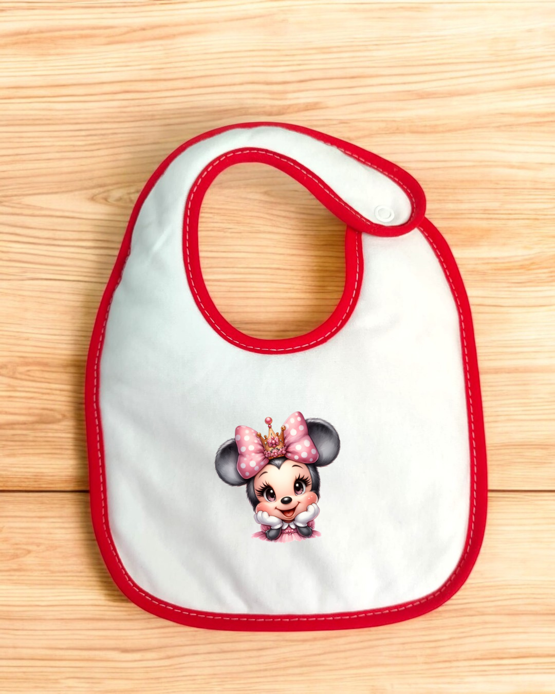 Babete branco com borda vermelha e personagem infantil estampada