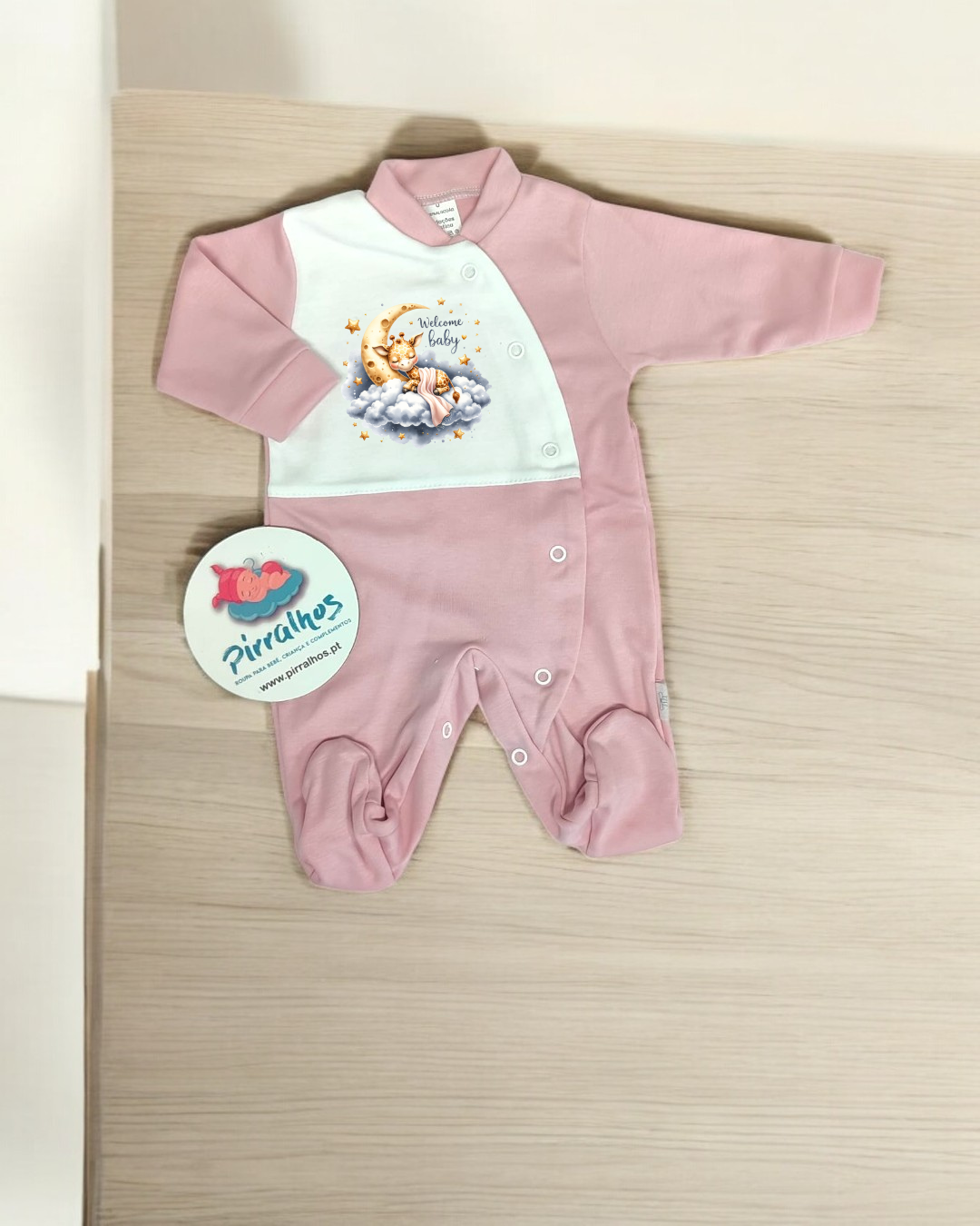 Macacão de bebé rosa e branco com estampa de ursinho e frase Welcome baby.